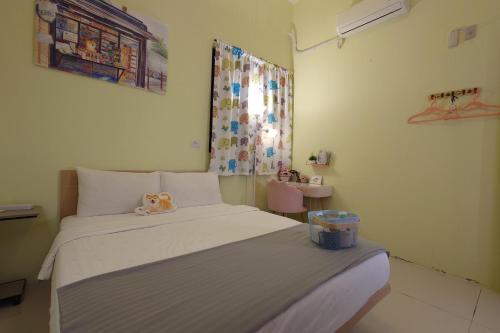 a bedroom with a bed with a stuffed animal on it at 台東市民宿賞星月沐文創館Enjoy Star丨網紅民宿丨親子友善丨寵物友善丨療癒民宿丨可包棟自動麻將機卡拉OK機丨雅致庭院丨近機場娜路彎酒店 l 可自助入住 in Taitung City