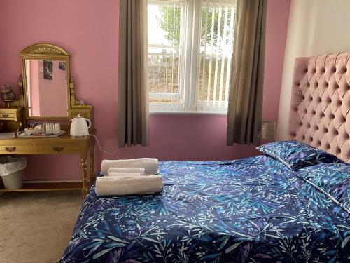 a bedroom with a bed and a vanity and a mirror at The Rosefield in Weymouth