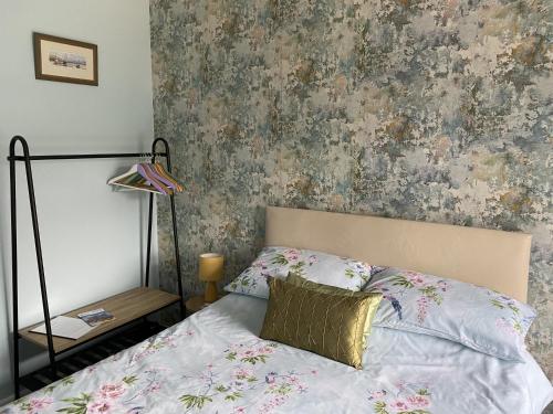 a bedroom with a bed with a floral wallpaper at The Rosefield in Weymouth