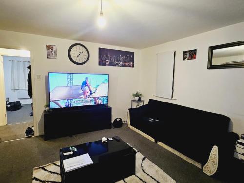a living room with a flat screen tv on a wall at Lovely Fully Furnished One Bed Flat To Let in Enfield Lock