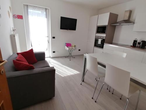 kuchnia i salon z kanapą i stołem w obiekcie Appartamento Meridiana w Arco