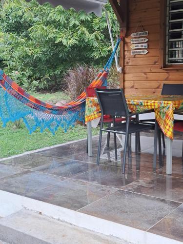 un patio con tavolo, sedie e amaca di Villa Cachiman a Pointe-Noire