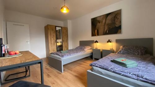a bedroom with two beds and a table and a desk at CHARLIE , Solingen Mitte, Ferien/Messe Wohnung für bis zu 5 Personen in Solingen