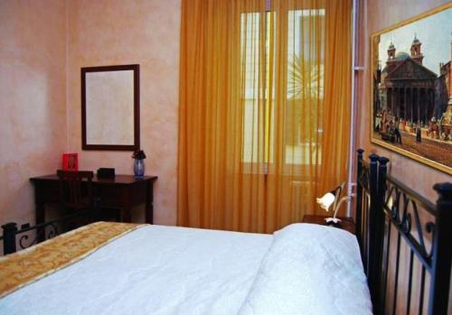 a bedroom with a bed and a desk and a window at Maestoso Locazione Turistica in Rome