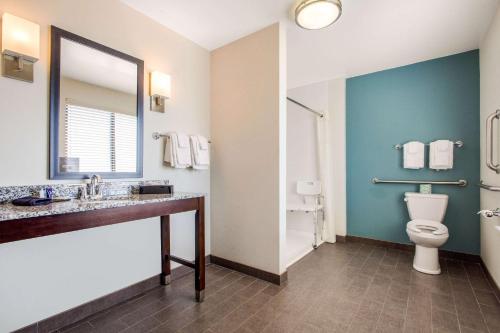 a bathroom with a toilet and a sink and a mirror at Sleep Inn & Suites Middletown - Goshen in Middletown