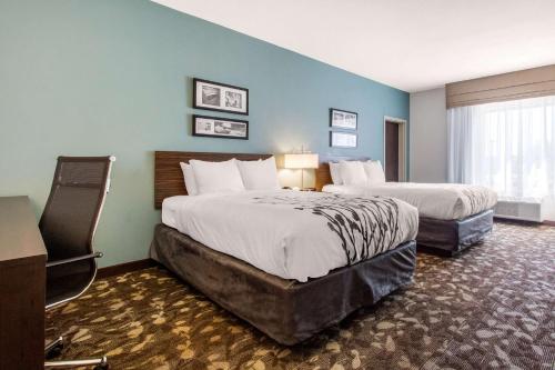a hotel room with two beds and a window at Sleep Inn & Suites Middletown - Goshen in Middletown
