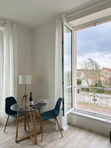 une salle à manger avec une table et des chaises et une grande fenêtre dans l'établissement Sunny Apt on D-Day Beach with Parking, à Saint-Côme-de-Fresné
