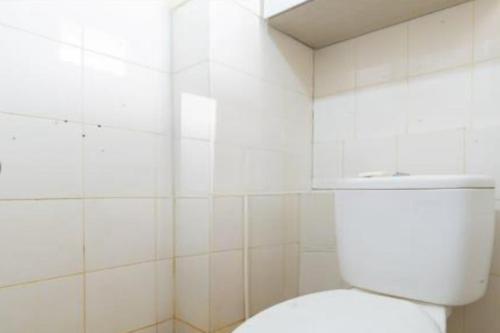 um WC branco numa casa de banho com azulejos brancos em OYO 93761 Kemang View By Room 88 em Bekasi