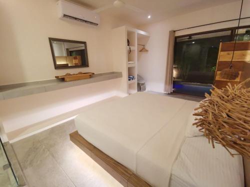- une chambre avec un grand lit blanc et une fenêtre dans l'établissement Kuun Taak Tulum, à Tulum