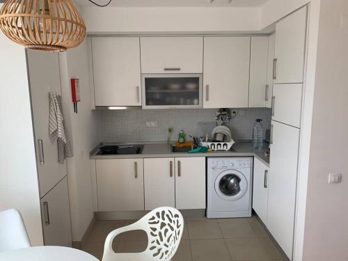 een keuken met witte kasten en een wasmachine bij Casa Maria in Lagos