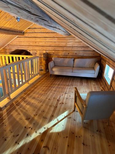 Cabin in the Woods في مالونك: غرفة معيشة مع أريكة في العلية