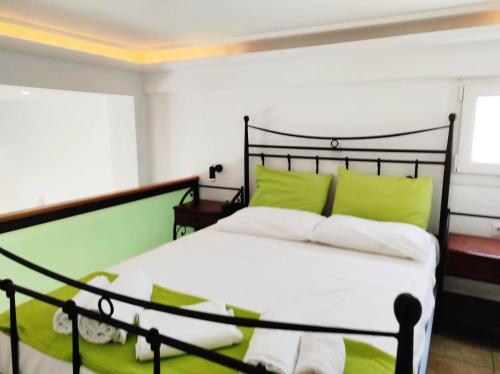 a bedroom with a large bed with green pillows at Villa Anna in ayios Petros