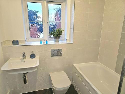 a bathroom with a sink and a toilet and a window at Modern & Fully Furnished in Bristol