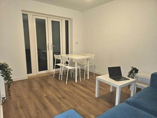 a living room with a table and a laptop on it at Modern & Fully Furnished in Bristol