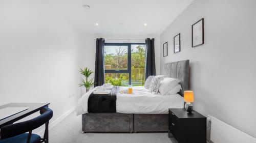a bedroom with a bed and a desk and a window at Axium Escape- 2 bed apartment, Birmingham City Centre in Birmingham