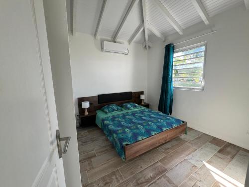um quarto com uma cama com um edredão azul e uma janela em Villa OCEANE em Trois-Rivières
