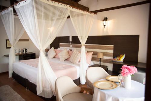 a bedroom with a bed with white drapes at Hotel Campestre La Periquera in Villa de Leyva