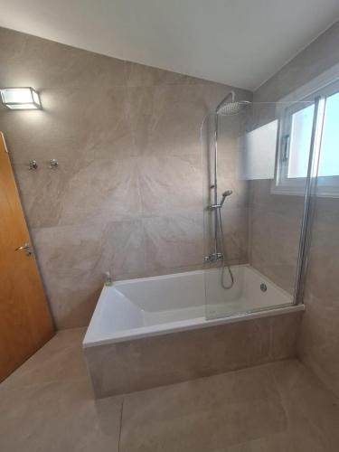 a bathroom with a bath tub with a shower at Villa suncity Boutique Beachfront in Ayia Napa