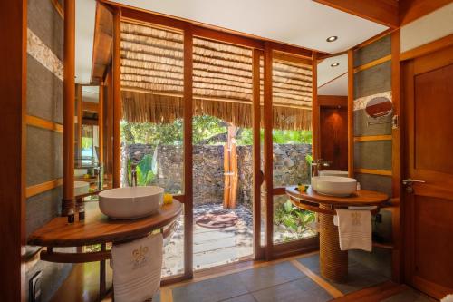 a bathroom with two sinks and a large window at Le Taha'a by Pearl Resorts in Motu Tautau