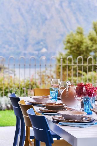 a table with plates of food and wine glasses at Design Villa in Tremezzina Villarnona Lake Como in Mezzegra