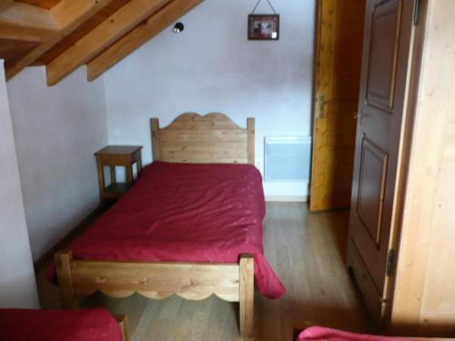 - une chambre avec un lit en bois et une couverture rouge dans l'établissement Chalet Les Aiguilles - 5 pièces 8 personnes 3 exposé Sud MAE-9404, à Valloire