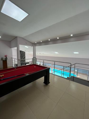 a pool table in a room with a swimming pool at Casa maria Júlia in Araguaína