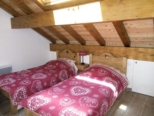 - une chambre avec 2 lits dans une pièce dotée de plafonds en bois dans l'établissement Chalet Les Pins - 3 Pièces pour 6 Personnes 84, à Valloire