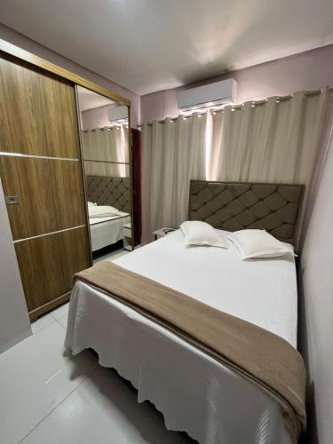 a bedroom with a large bed and a mirror at Hotel pousada maria Julia in Araguaína