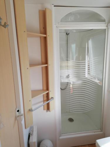 d'une armoire en verre avec une douche en verre dans la salle de bains. dans l'établissement MOBIL HOME 4 personnes en bord de mer - Camping les Goélands, à Saint-Martin-Plage