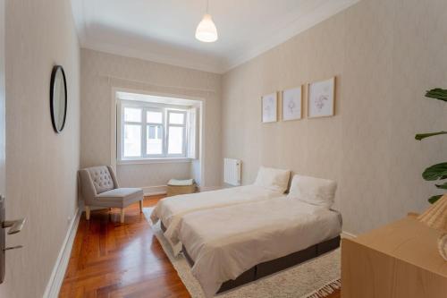 1 dormitorio con 1 cama y 1 silla en Charming Principe Real perfect for Families en Lisboa