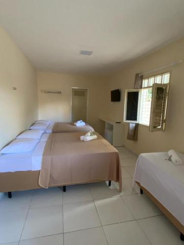 a hotel room with two beds and a tv at Pousada Manaíra in João Pessoa
