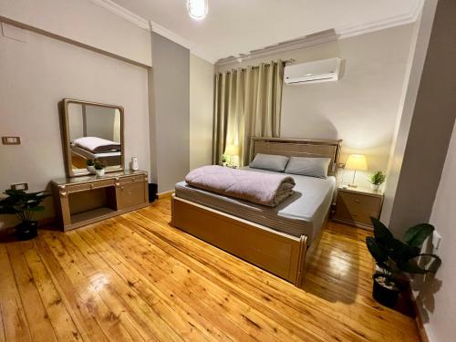Un dormitorio con una cama y un espejo grande. en Modern 2BR Apartment in Maadi, en El Cairo