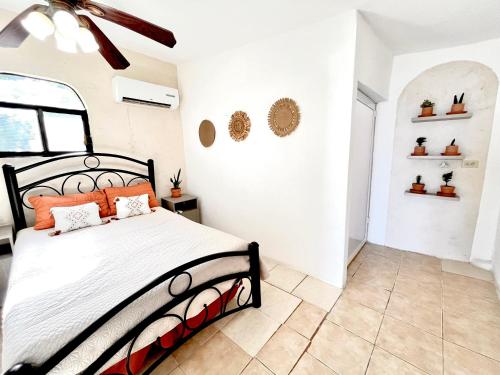 a bedroom with a bed with orange pillows on it at Casita Costa Azul in San José del Cabo