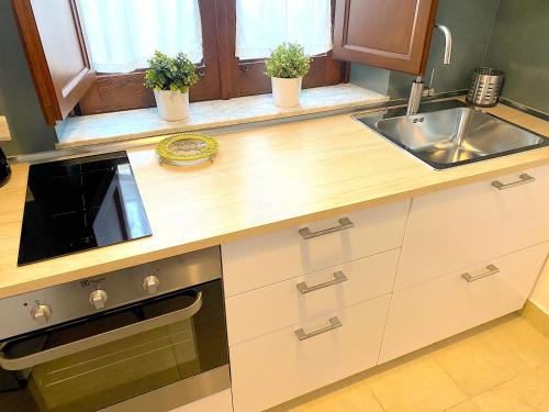 a kitchen with a sink and a stove at Archè Apartment in Taormina