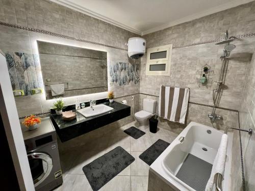 Un baño con lavabo, inodoro y bañera. en Modern 2BR Apartment in Maadi, en El Cairo
