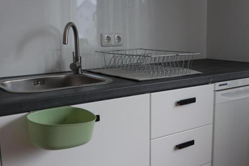 a kitchen counter with a sink and a strainer at Gemütlich schnuckelige Wohnung mit -Sommer- Pool in Nidderau