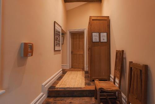 a hallway with a wooden door and a wooden stool at The Jodrell Luxury Suites in Whaley Bridge