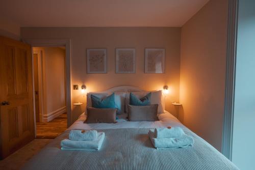 a bedroom with a bed with two towels on it at The Jodrell Luxury Suites in Whaley Bridge