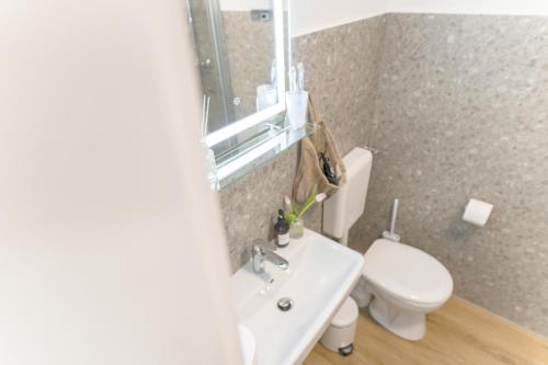 a bathroom with a white toilet and a sink at Wolfsburg Innenstadt - HAPPYHOME - direkt in der Porschestraße, 5 Personen & Kind, 3 Zimmer in Wolfsburg