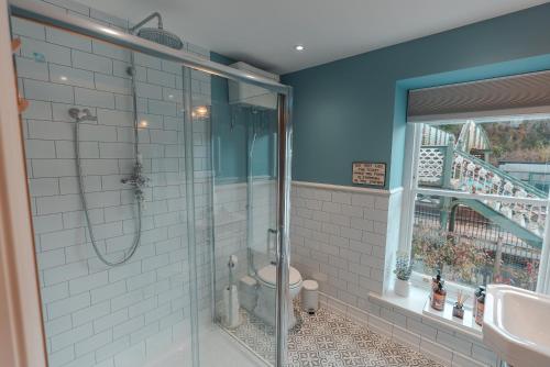 a bathroom with a shower and a toilet and a sink at The Jodrell Luxury Suites in Whaley Bridge