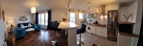 une cuisine et un salon avec des chaises bleues et une table dans l'établissement Appartement avec vue panoramique sur les montagnes, au Bourget-du-Lac