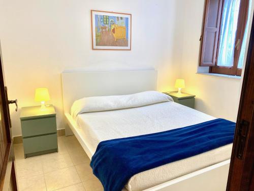 タオルミーナにあるArchè Apartmentのベッドルーム1室(ベッド1台、テーブルにランプ2つ付)