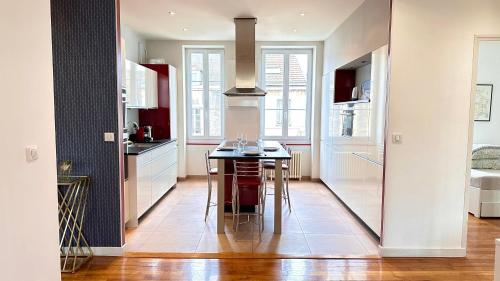 une cuisine avec une table et des chaises dans l'établissement La chouette de Dijon, à Dijon