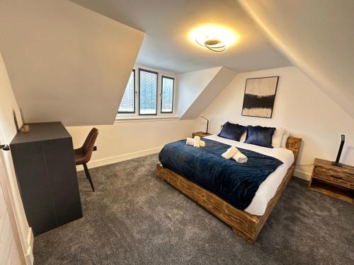 a bedroom with a bed and a desk and window at Smiddy Cottage Bauds in Buckie