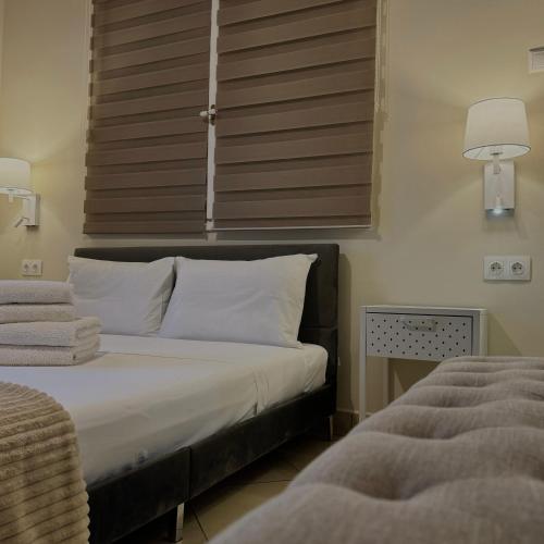 a bedroom with a bed with white pillows and a window at Vasilios Marinos Rooms in Korinthos