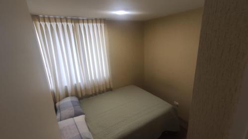 ein kleines Schlafzimmer mit einem Bett und einem Fenster in der Unterkunft LIMA - RIMAC Departamento in Lima