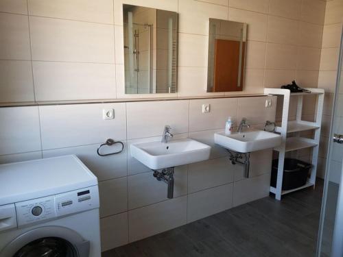 ein Badezimmer mit 2 Waschbecken und einer Waschmaschine in der Unterkunft Cosy apartment in Porta Westfalica in Porta Westfalica
