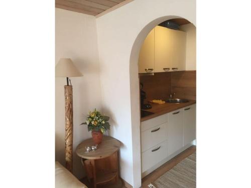 una cocina con armarios blancos y una mesa en una habitación en Snug apaartment in Oberammergau, en Oberammergau