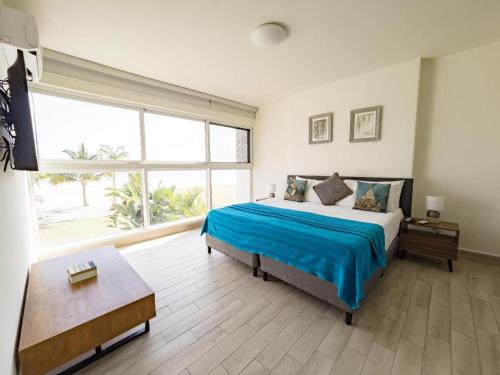 a bedroom with a large bed and a large window at Sanctuary by Playa Caracol Residences in Punta Chame