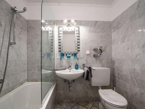 een badkamer met een toilet, een wastafel en een douche bij Holiday apartment Leo by the lake in Bad Wiessee